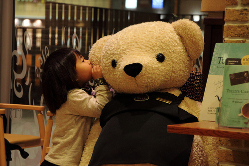 小萝莉爬在大熊脸上亲一下可爱趣图gif搞笑图片