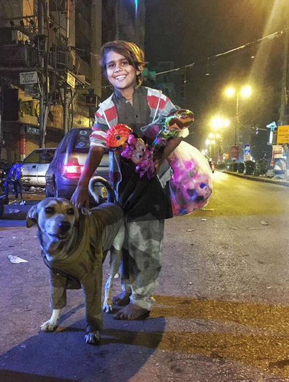 一个衣衫褴褛还没有鞋的小男孩，把最宝贵的长袖毛衣穿在小狗伙伴身上儿童gif搞笑图片