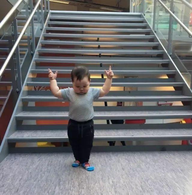 孩子自己从上面的楼梯安全的到大了地面，于是给自己起了个特别牛气的姿势~儿童gif搞笑图片