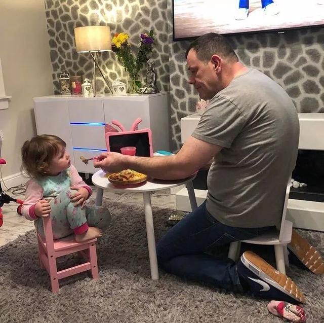 职业是拳击教练的爸爸每天都要窝在这个小凳子上喂女儿吃饭，没办法，硬汉的妥协儿童gif搞笑图片