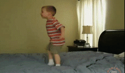 小孩在床上直接被枕头砸翻儿童gif搞笑图片